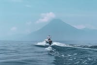 Boat in the middle of the lake with Atitlan Volcano views