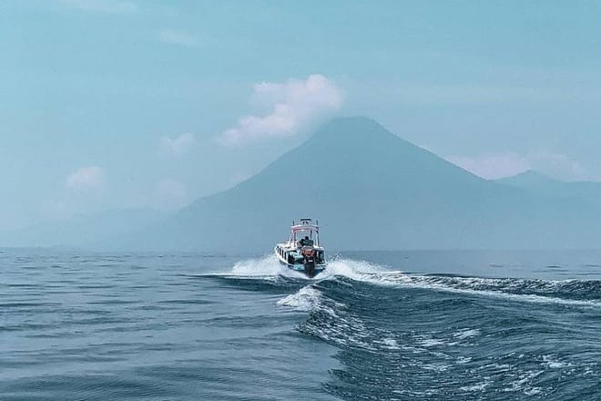 Boat in the middle of the lake with Atitlan Volcano views