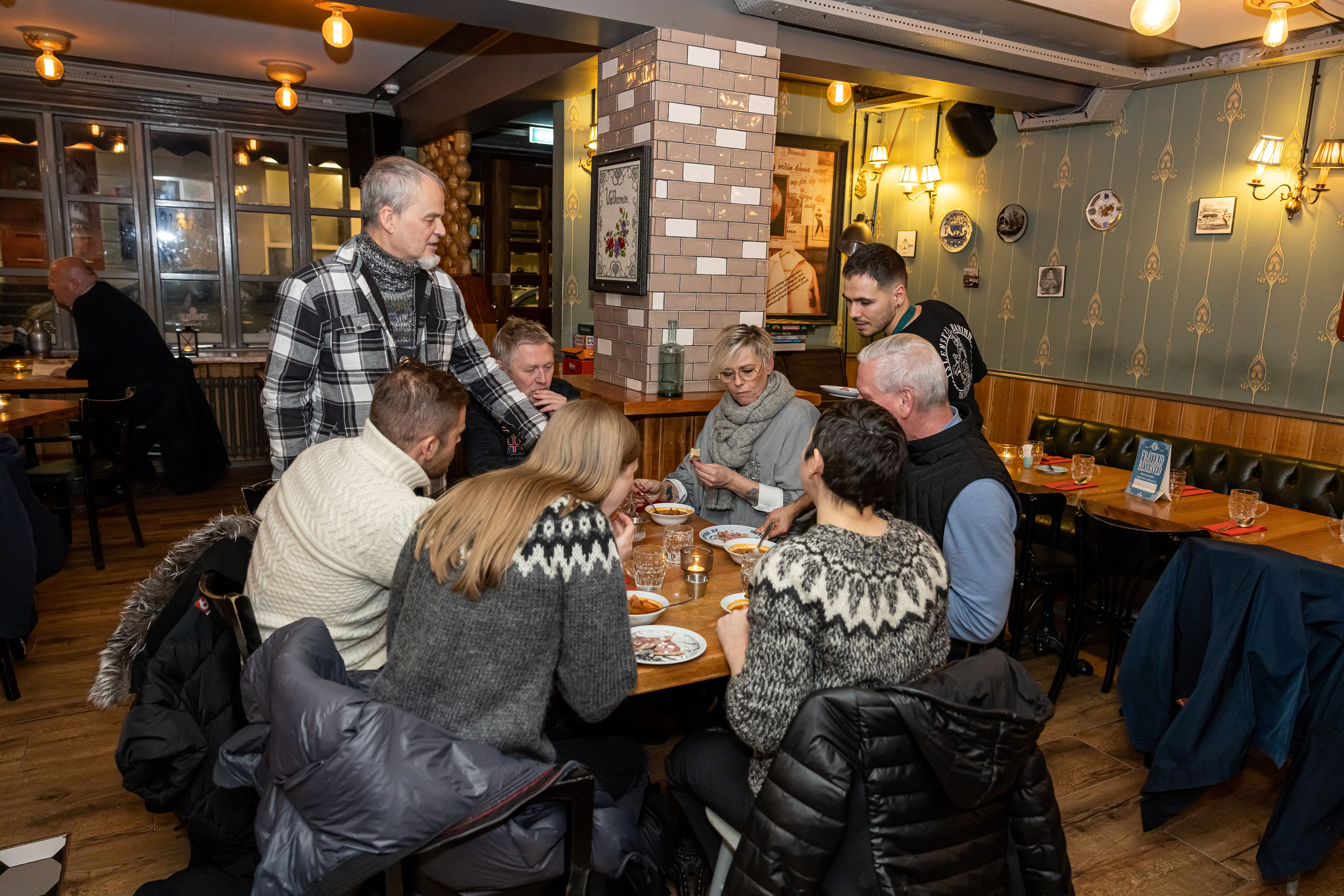 A small group of guests enjoying Icelandic Meat Soup while sitting at a circular table