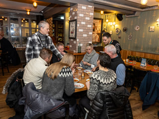 A small group of guests enjoying Icelandic Meat Soup while sitting at a circular table