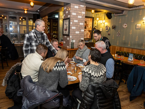 A small group of guests enjoying Icelandic Meat Soup while sitting at a circular table