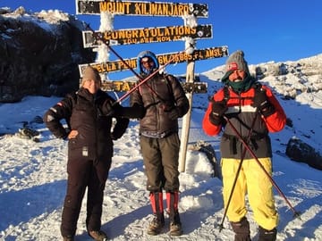 A shared triumph: Reaching the majestic Uhuru Peak with our expert team.