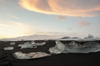 Pieces of ice on black sand near Glacier Lagoon Iceland