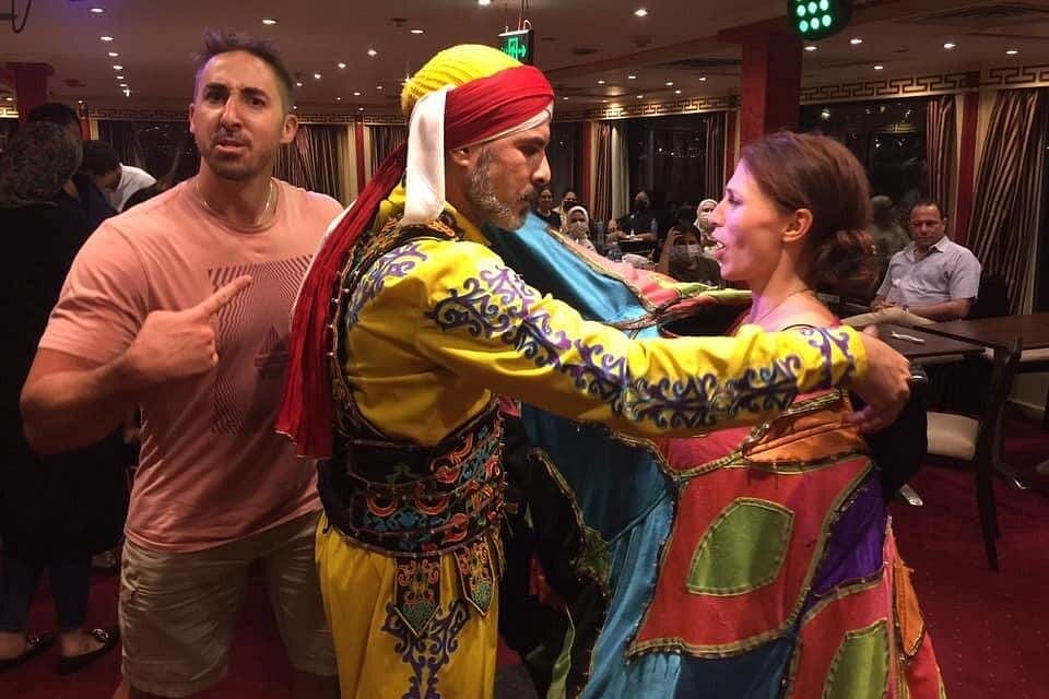 A traditional Egyptian Tanoura performer spinning in a brightly colored skirt on the floor of the Andrea Memphis cruise