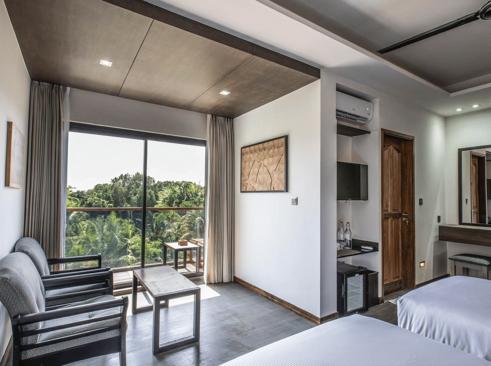 A luxurious room at Aroom Ataraxis Grand and Spa Fuvahmulah with a view of palm trees.