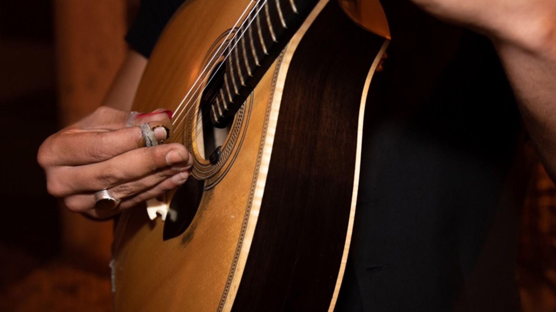 Image of a Portuguese guitar being played, part of Cooltour Oporto's Fado Dinner Show with Night Tour