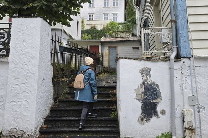 Local guide climbing stone steps in Lille Øvregaten, Bergen
