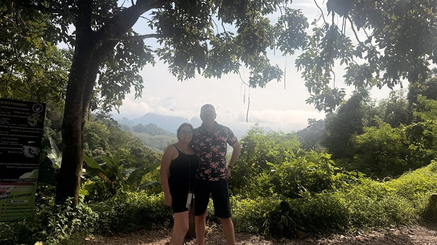 Two hikers at a viewpoint on a forest trail in Khao Sok