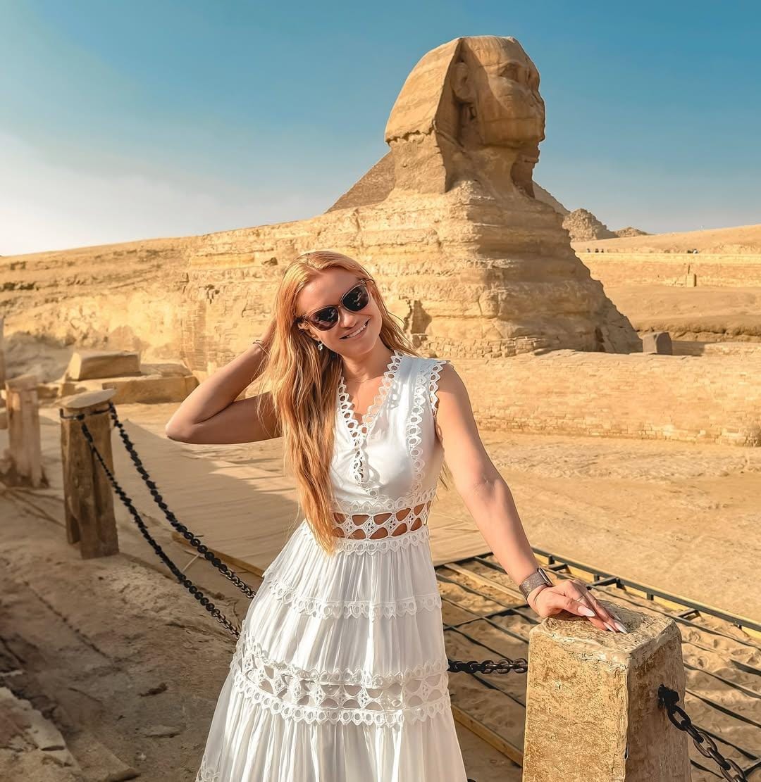 Tourist posing at Great Sphinx during Egypt guided tour.