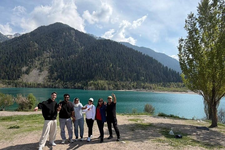 View of Issyk Lake surrounded by tall mountains and green forests in southeastern Kazakhstan