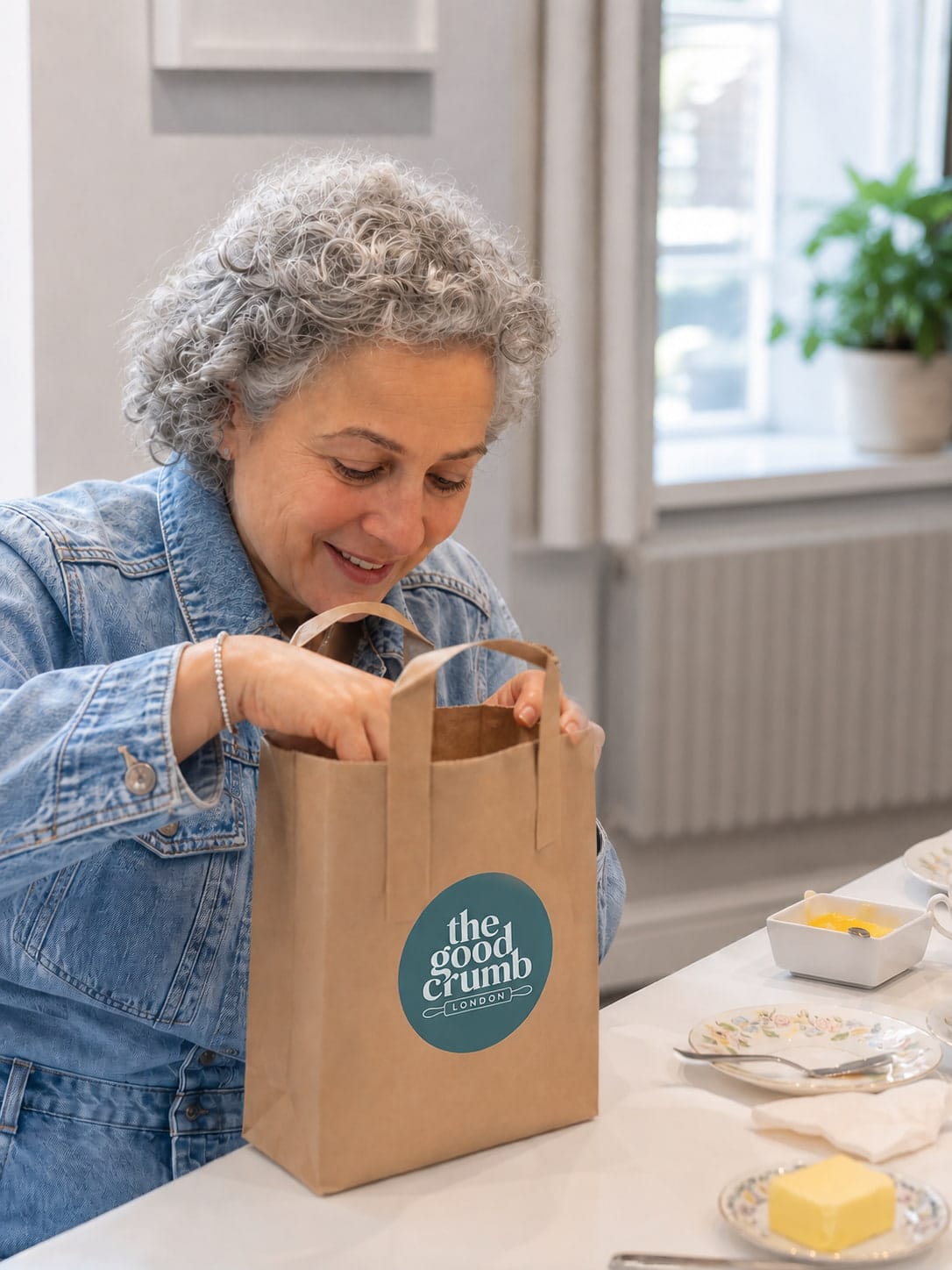 A lady peering into a bag to see her bakes inside
