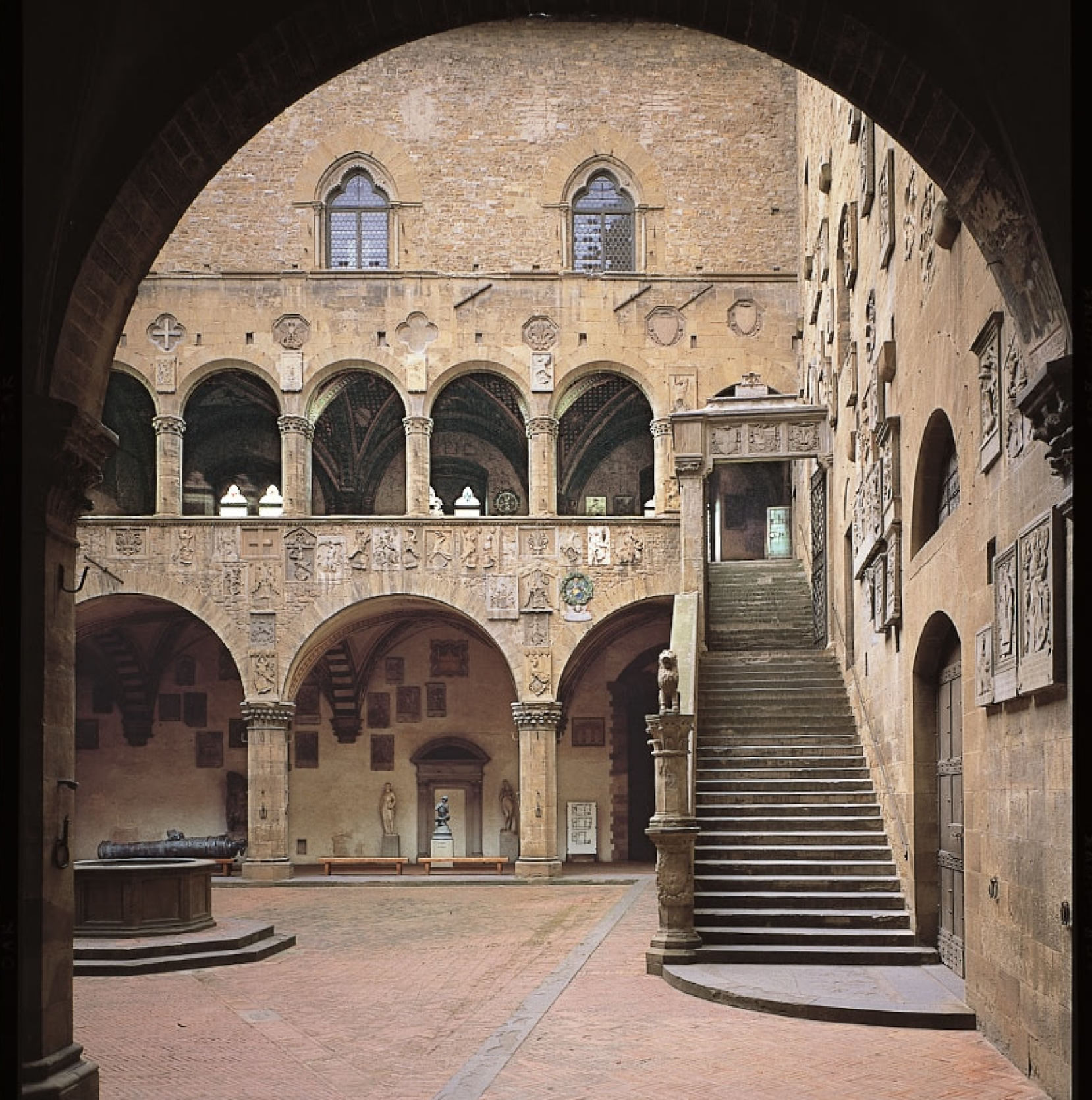 View of the internal cloister of the Bargello Museum with its medieval arches, stone staircase and well