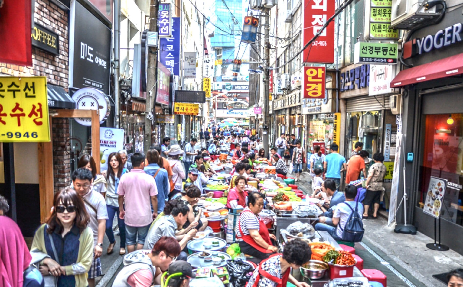 Busy street scene inside Gukje Market with visitors and food stalls