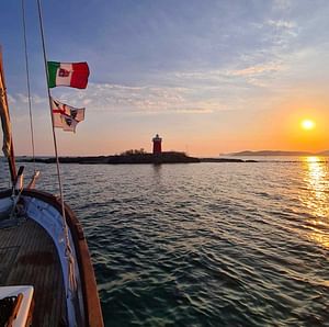 Vintage boat sailing excursion in the Gulf of Alghero at sunset with tasting