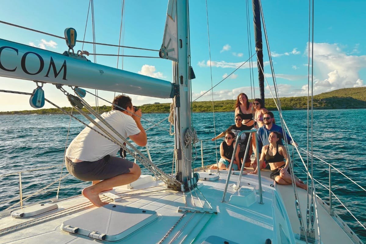 friends enjoying sunset photo moment at bow of sailing yacht galaxie at Sunset