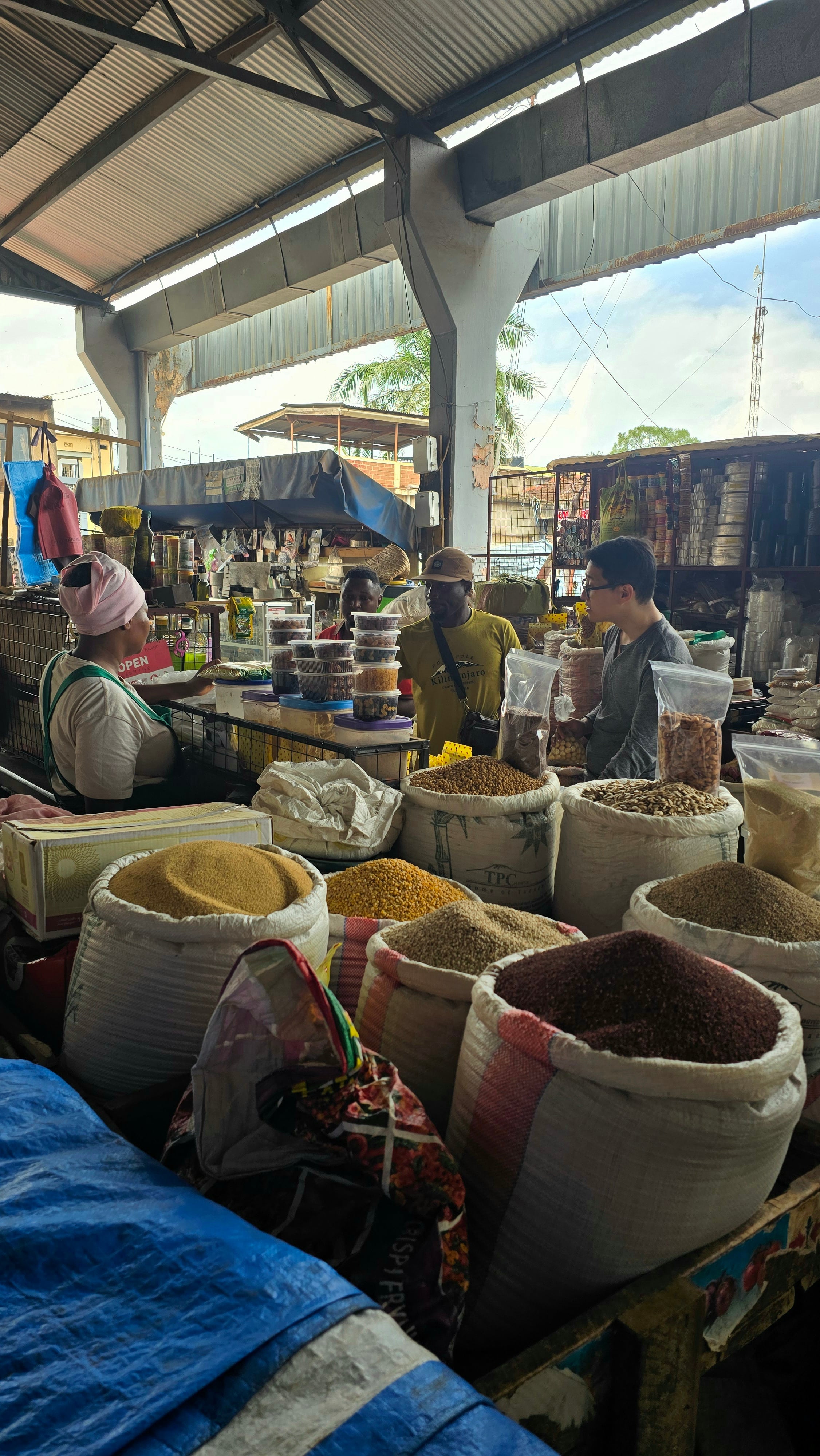 A colorful local market stall in Moshi displaying fresh spices, grains, and traditional goods.