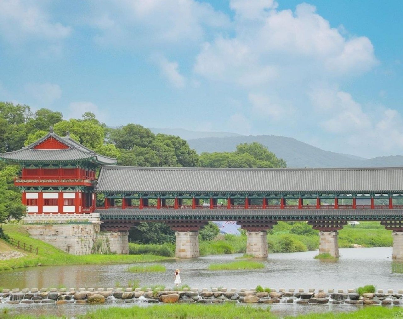 Woljeonggyo Bridge spanning across the river with traditional Korean architecture.