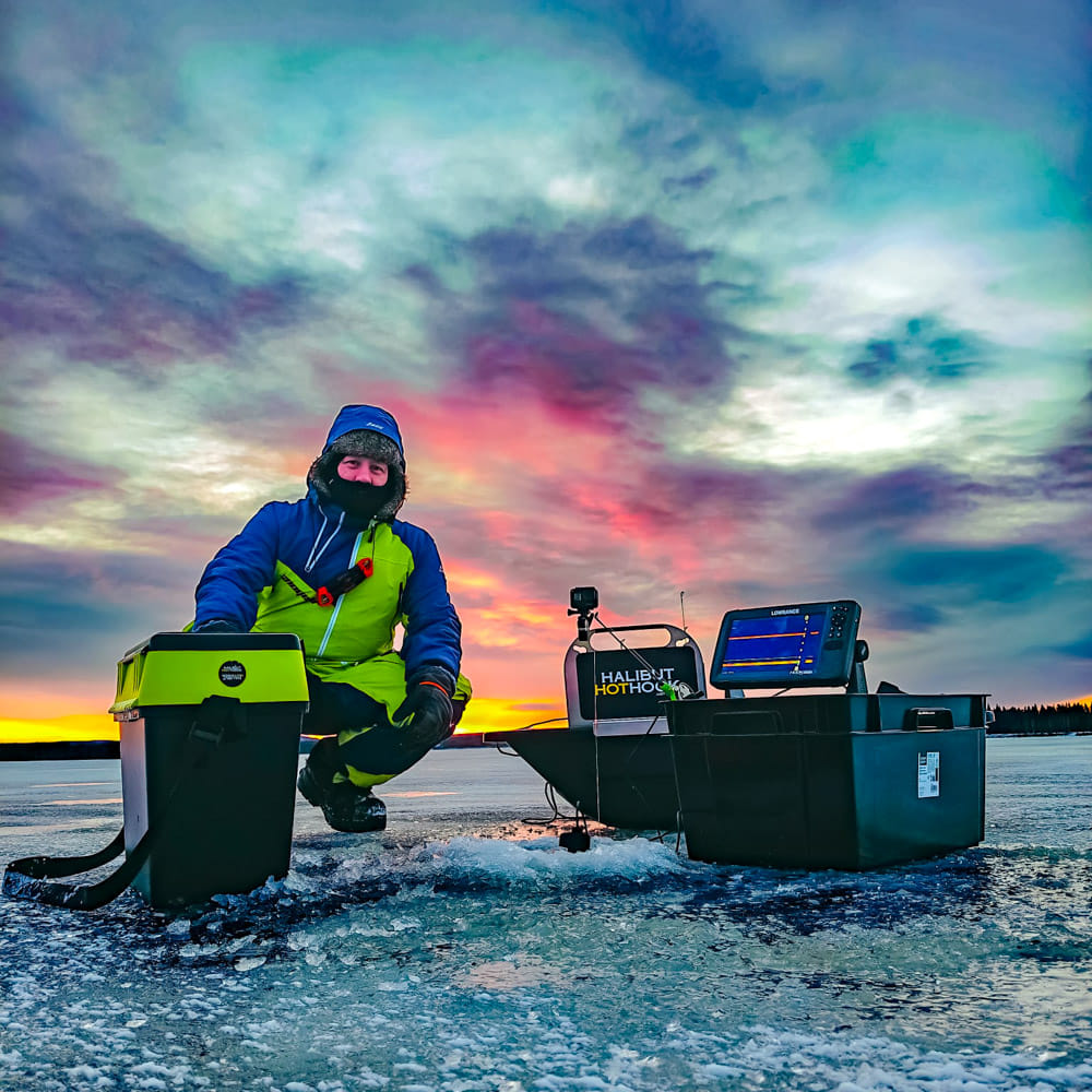 A man on the ice with ice fishing gear