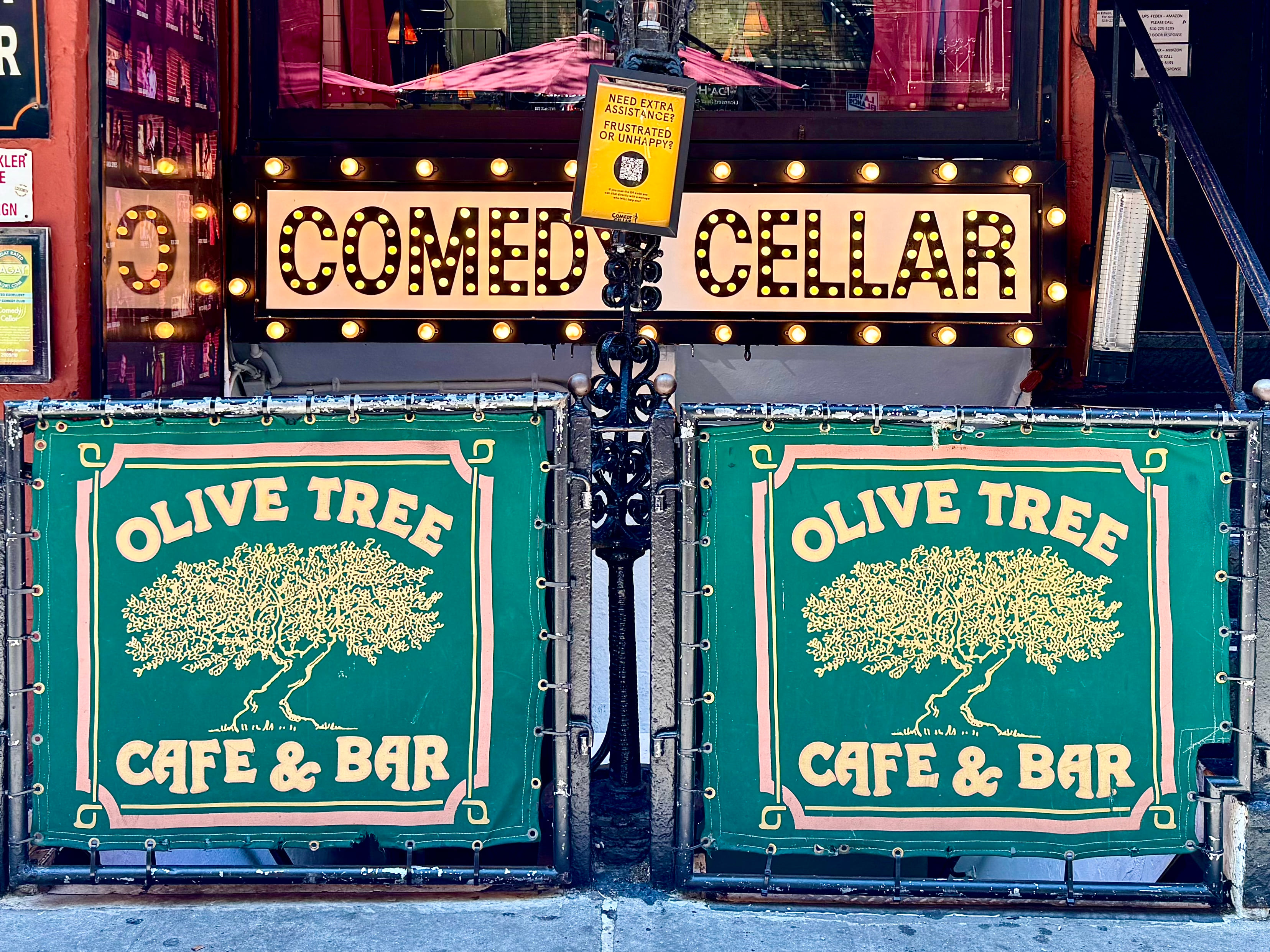 The Comedy Cellar storefront beneath the Olive Tree Cafe sign on MacDougal Street.