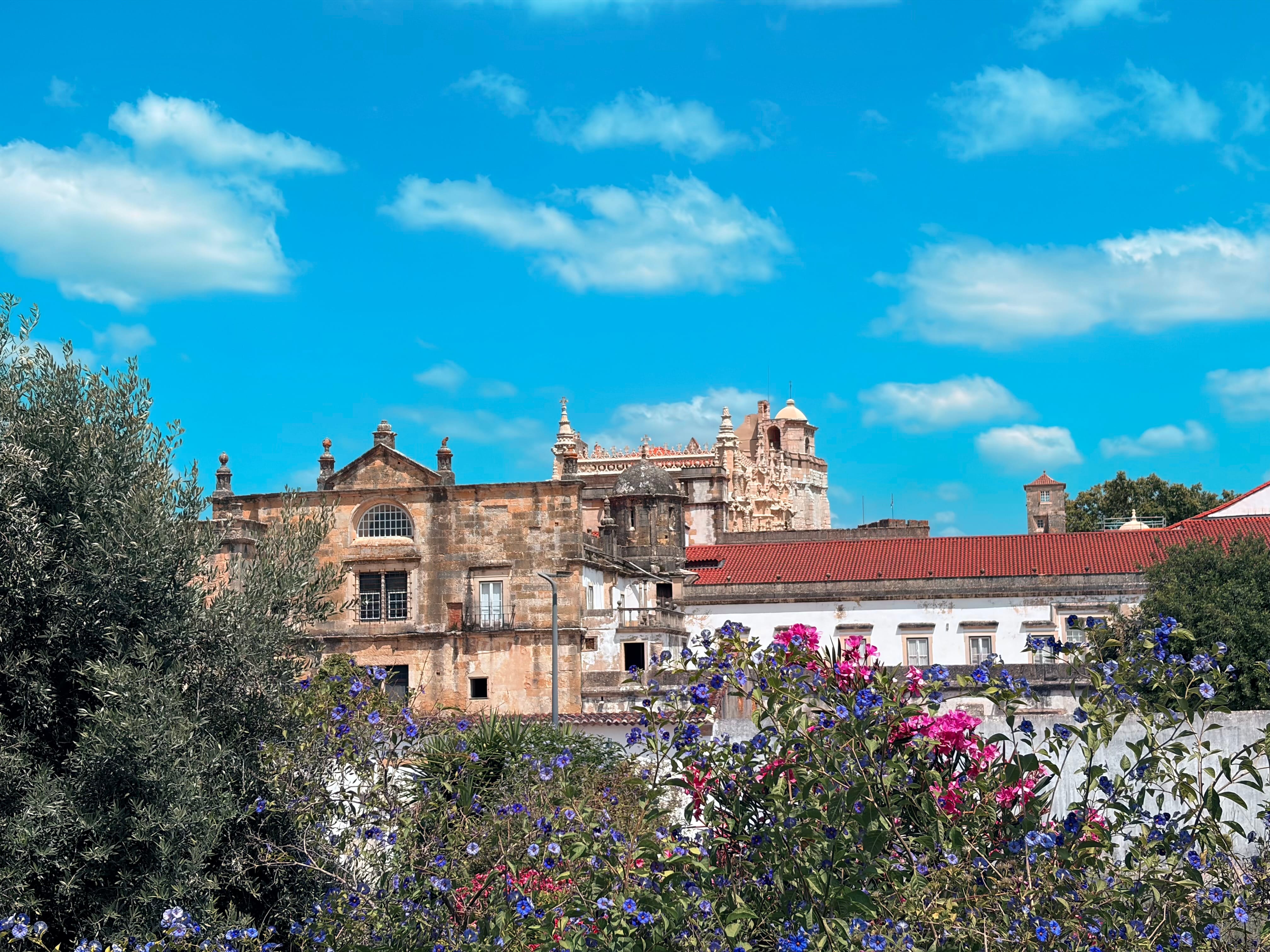 Vista em perspetiva do Claustro de D. João III no Convento de Cristo em Tomar, destacando a arquitetura renascentista com colunas de pedra e