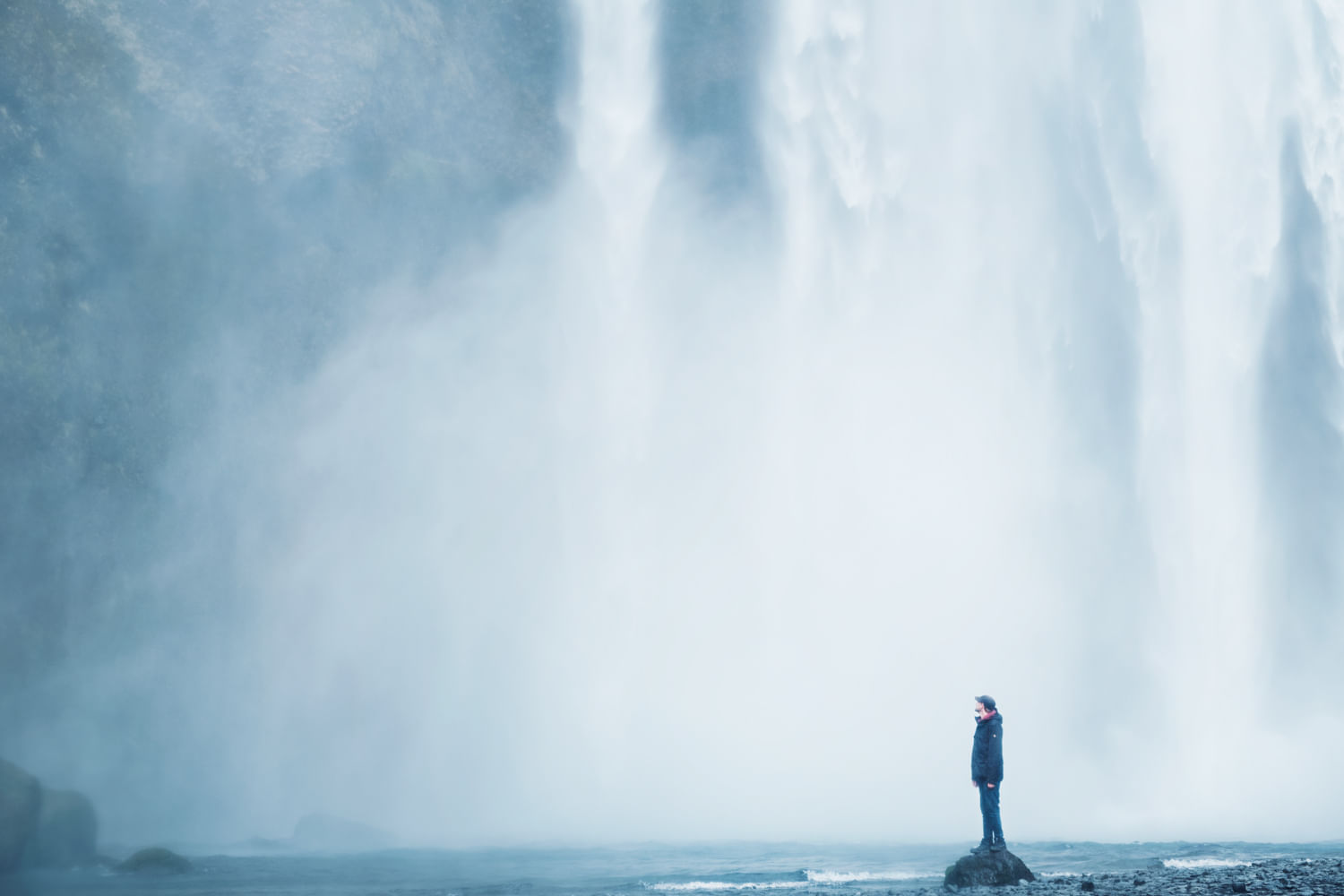 Feeling the power from dropping waters of Skógarfoss waterfall Iceland