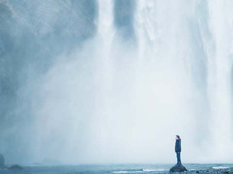 Feeling the power from dropping waters of Skógarfoss waterfall Iceland