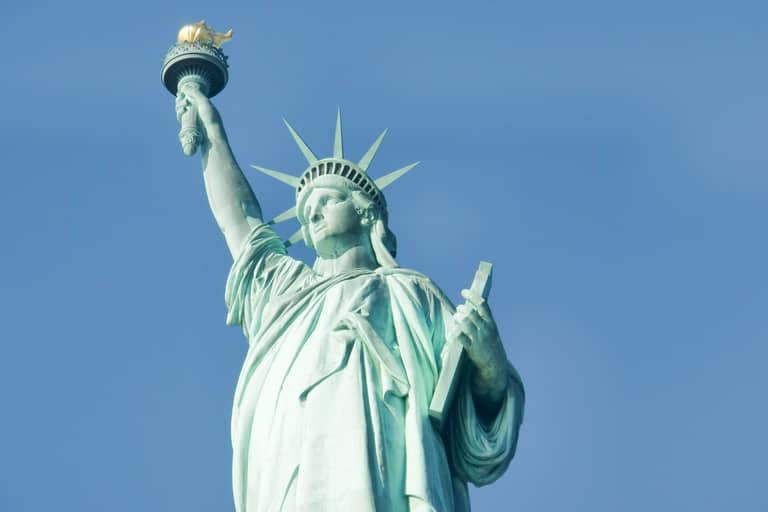Statue of Liberty torch and crown against clear blue sky in New York Harbor