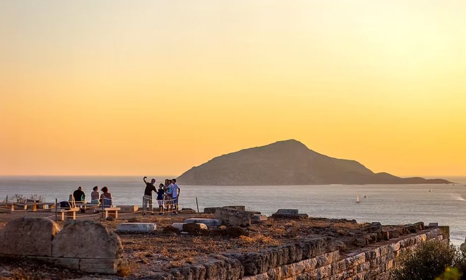 Travelers enjoying the scenic beauty and history of the Poseidon Temple near Athens.