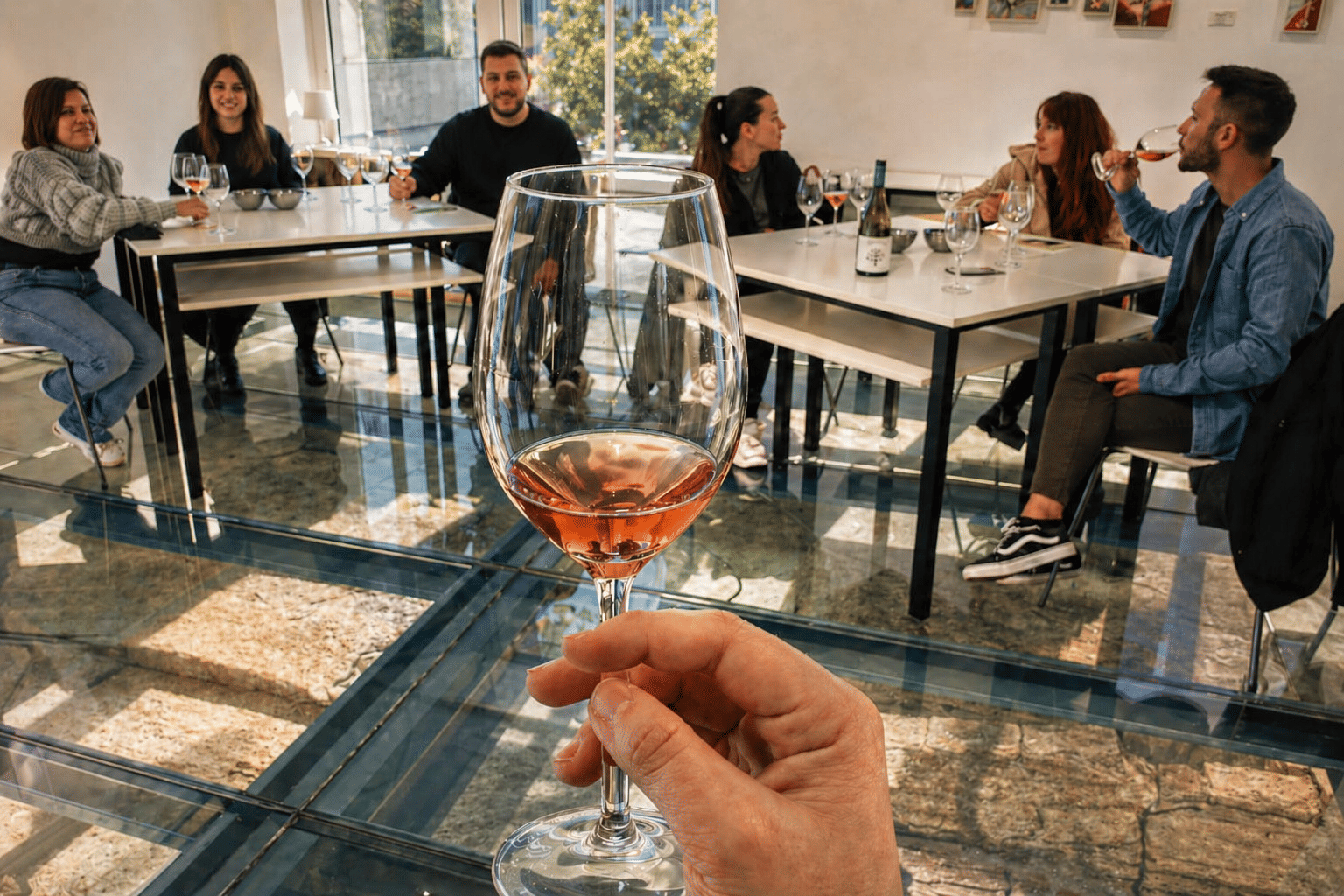 Close-up of a glass of rosé wine during a tasting experience above a historic underground cellar in Valencia, Spain