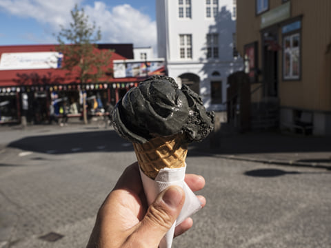 A picture of a ice cream cone with a black coloured scoop of liquorice flavoured Ice Cream.
