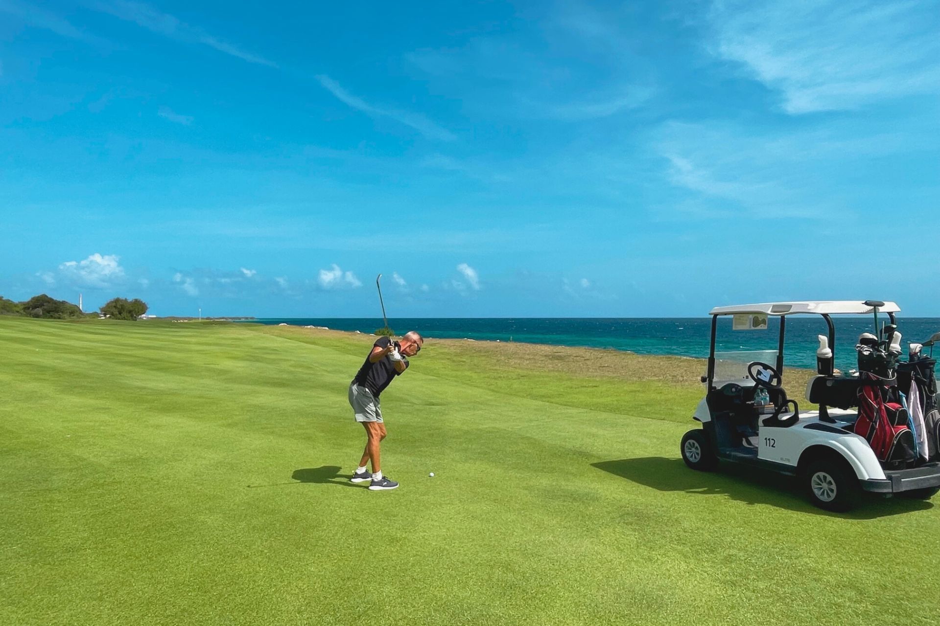 handsome young men playing golf on the Old Quarry Golf Course next to the Caribbean Sea