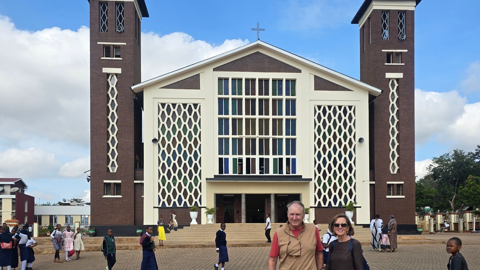 A front view of the iconic Christ the King Cathedral in Moshi with visitors in the foreground.
