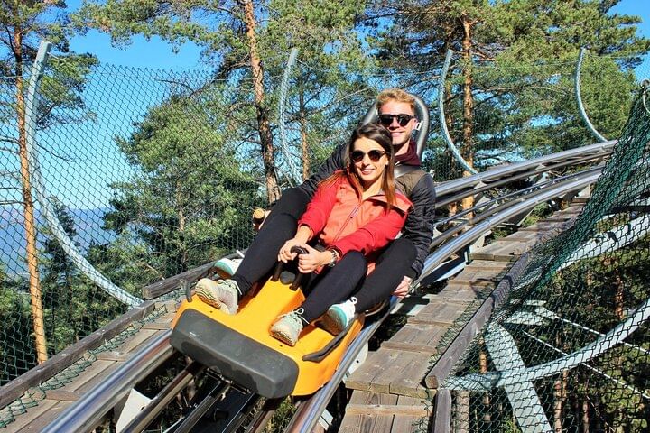 La pareja disfruta de un día soleado y divertido en la montaña rusa alpina de Peña Aventura en Ribeira de Pena