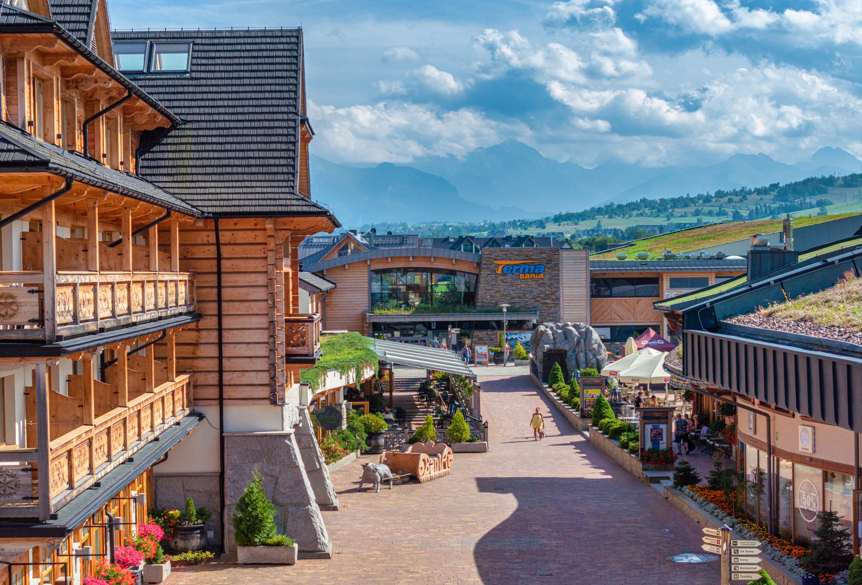 Terma Bania entrance building with Tatra Mountains panorama and highland resort promenade