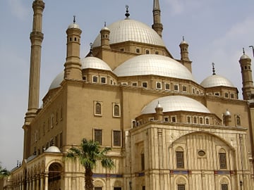 Exterior view of the historic Mosque of Muhammad Ali with its iconic Ottoman domes and towering minarets at the Saladin Citadel in Cairo.