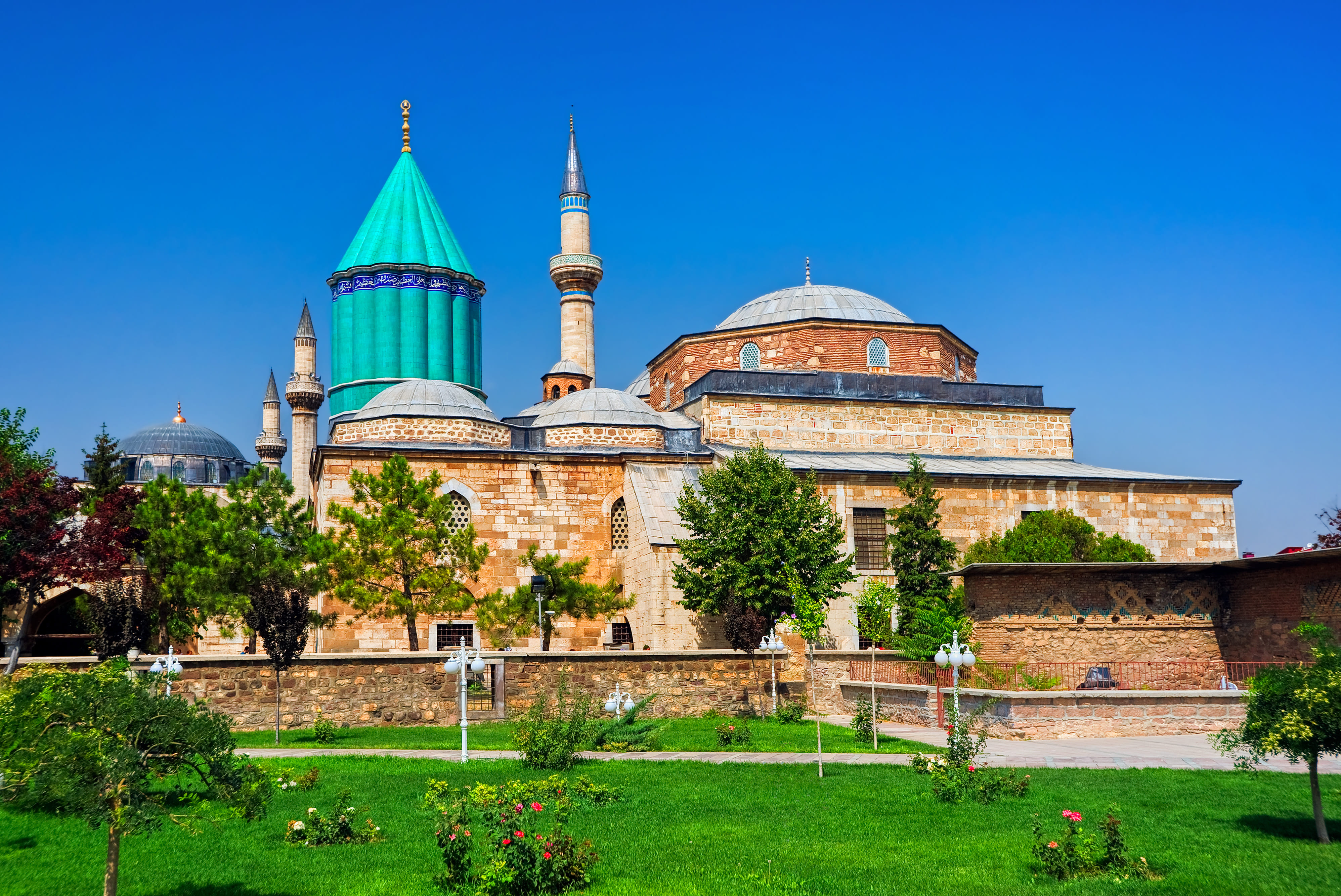 “Ornate green-tiled dome and entrance of the Tomb of Mevlana in Konya, Turkey, surrounded by intricate Islamic architectural details.”