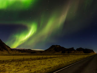 The Northern Lights dance across the Icelandic night sky.