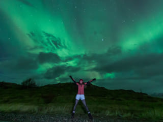 Woman under the aurora's glow.