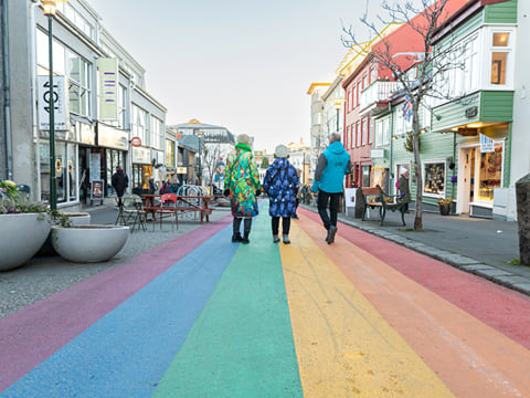 A group of travellers walking down the Rainbow Street in downtown Reykjavik