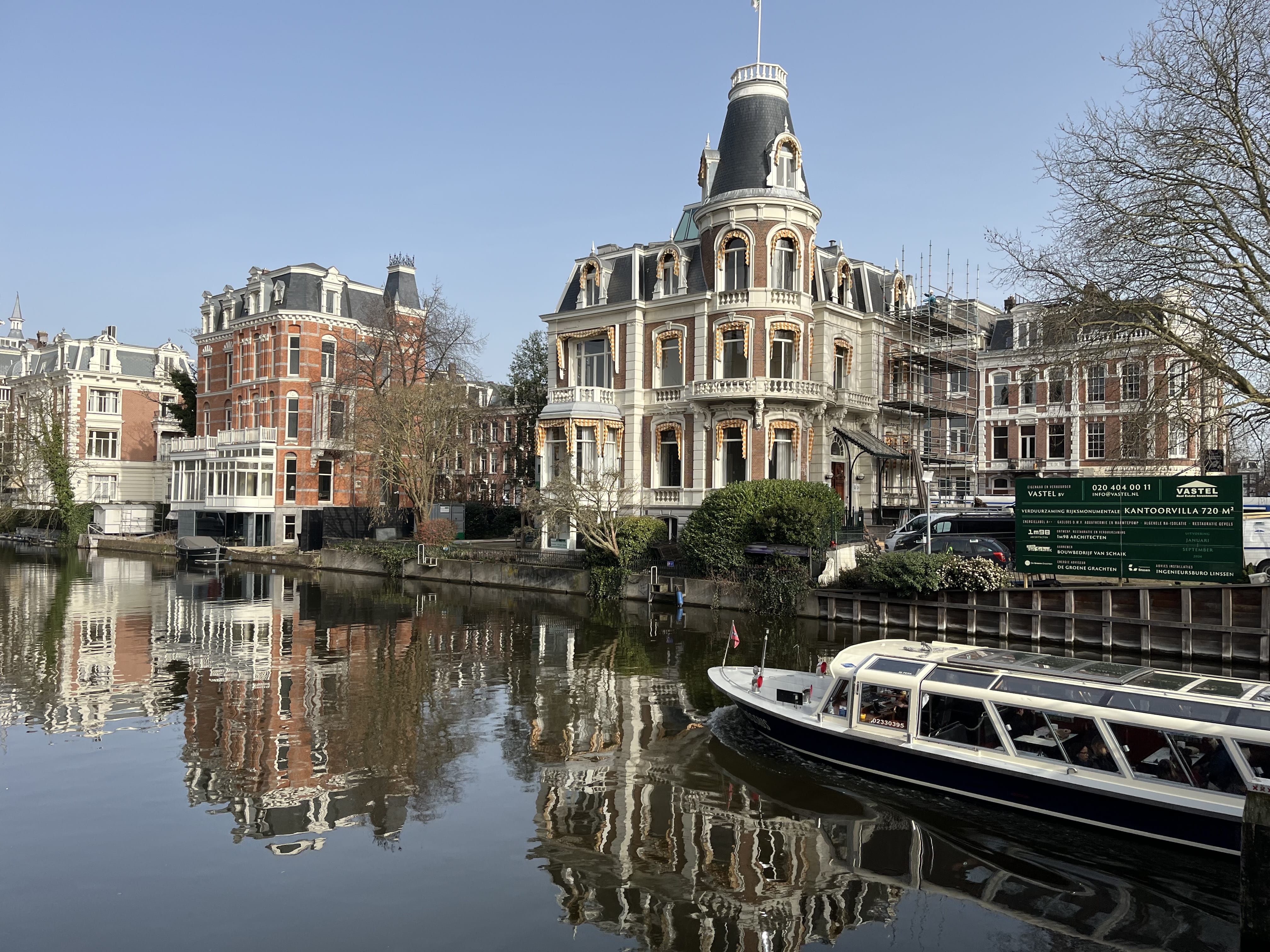 Canal boat cruising past historic canal houses in Amsterdam during a shore excursion canal cruise