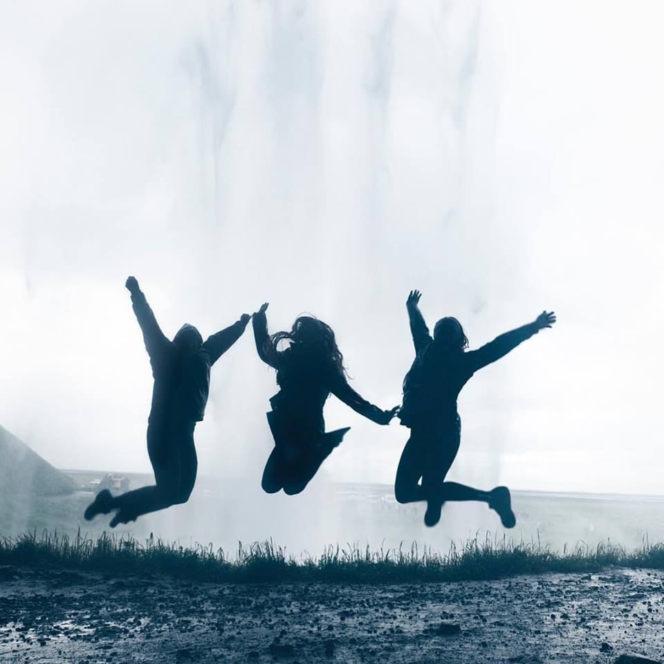 Jumping with joy behind Seljalandsfoss waterfall