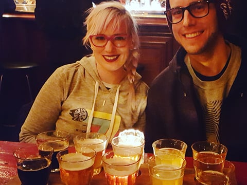 A couple smiling for the camera during a beer sampling