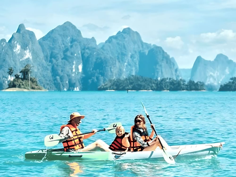 Family kayaking beneath limestone peaks