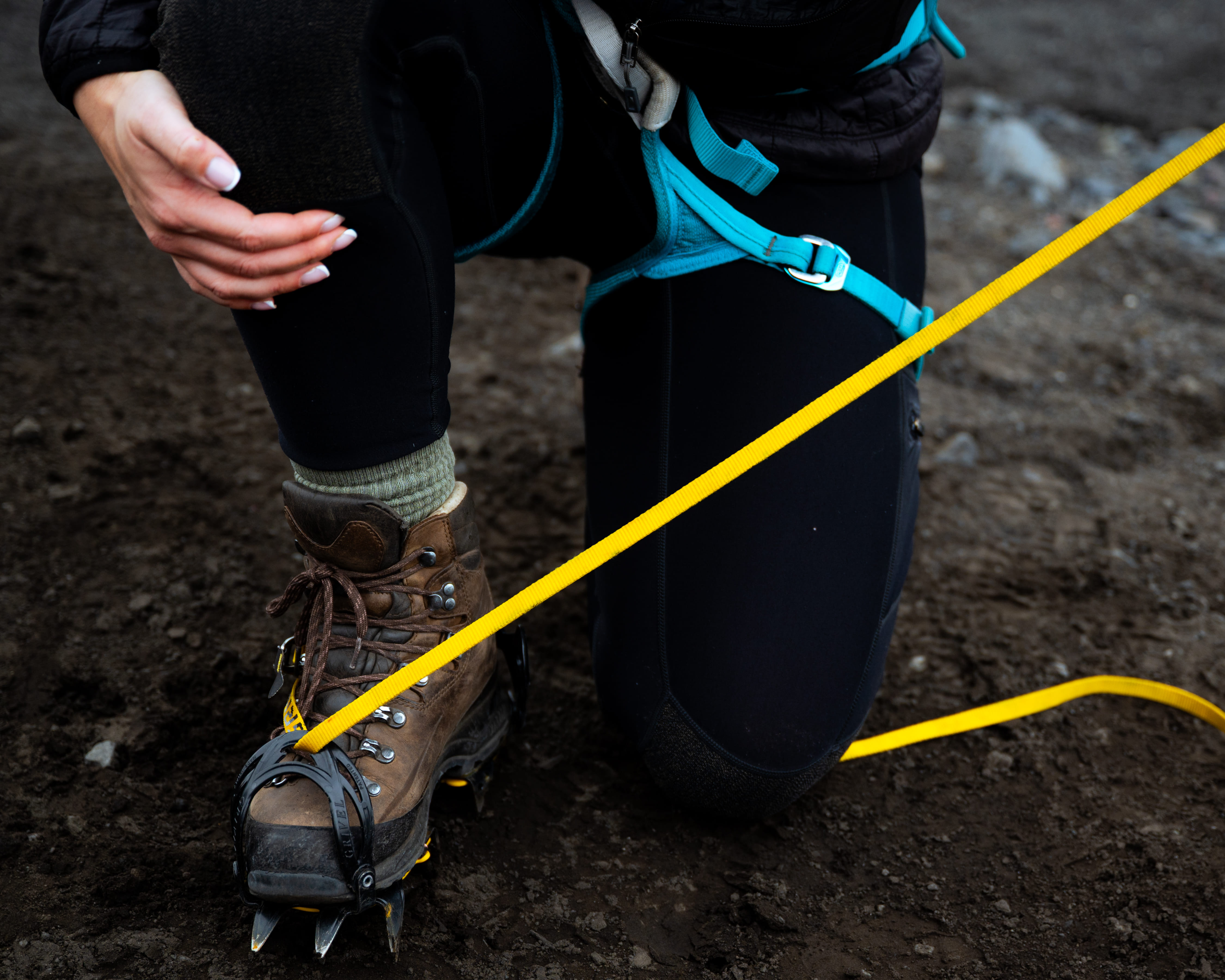 Close-up of hiking boot with crampons and safety rope for a guided glacier ascent