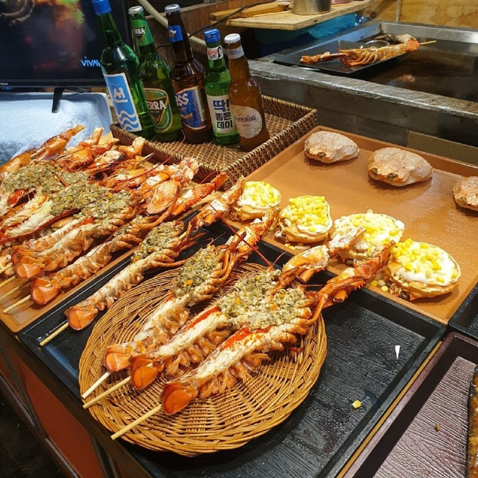 Cheese-topped grilled lobster displayed at a street food stall in Bupyeong Market.