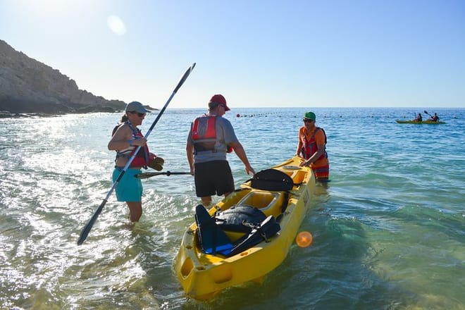 Guided kayak tour Los Cabos instructor helping guests enter water two bays snorkeling