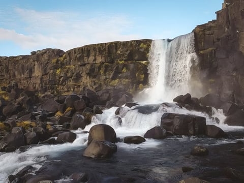 Öxarárfoss waterfall flowing through lava rocks in Þingvellir, Iceland