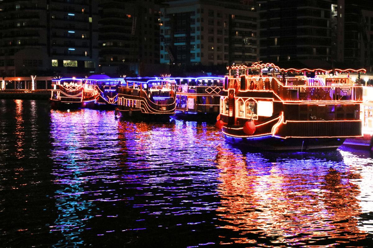 Illuminated dhow boats during an evening dinner cruise in Dubai Marina