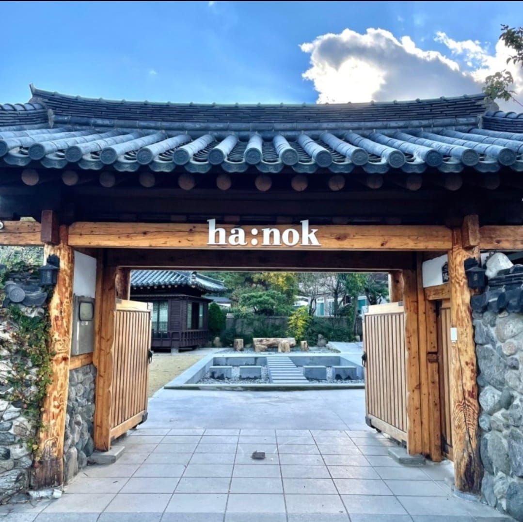 Entrance of a traditional Korean hanok café with wooden gate and tiled roof in Busan