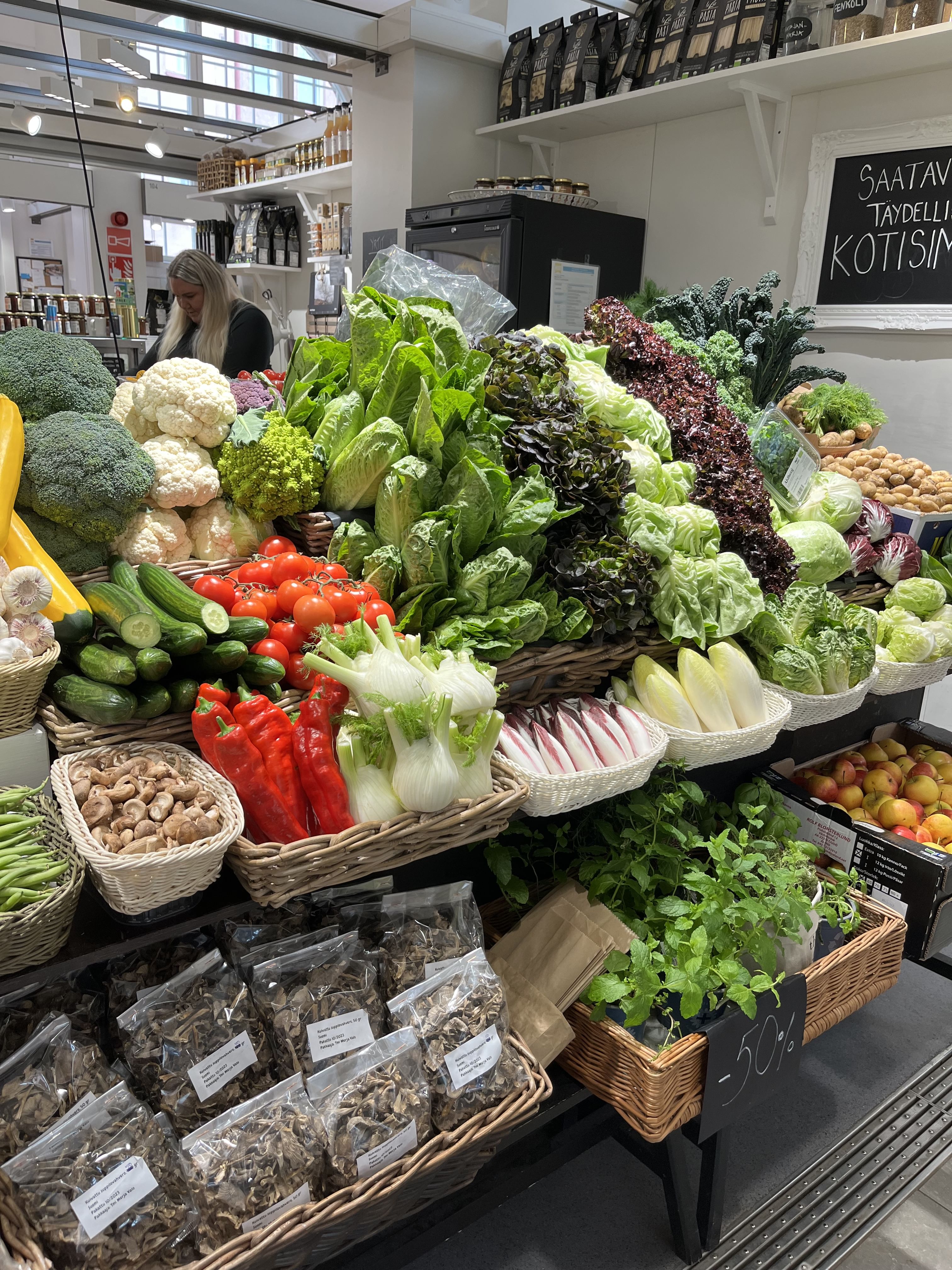 Värikkäitä vihanneksia kauppiaan tiskillä